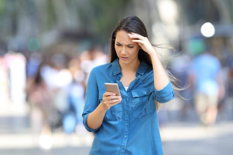 front,view,portrait,of,a,worried,woman,checking,smart,phone