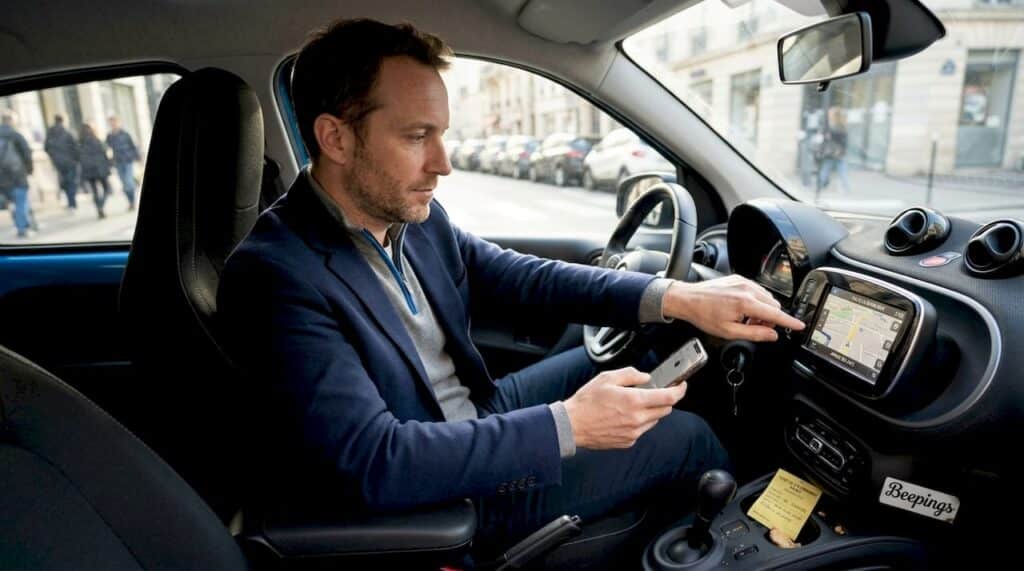 Un automobiliste règle son GPS depuis le tableau de bord alors qu’il circule en centre-ville.